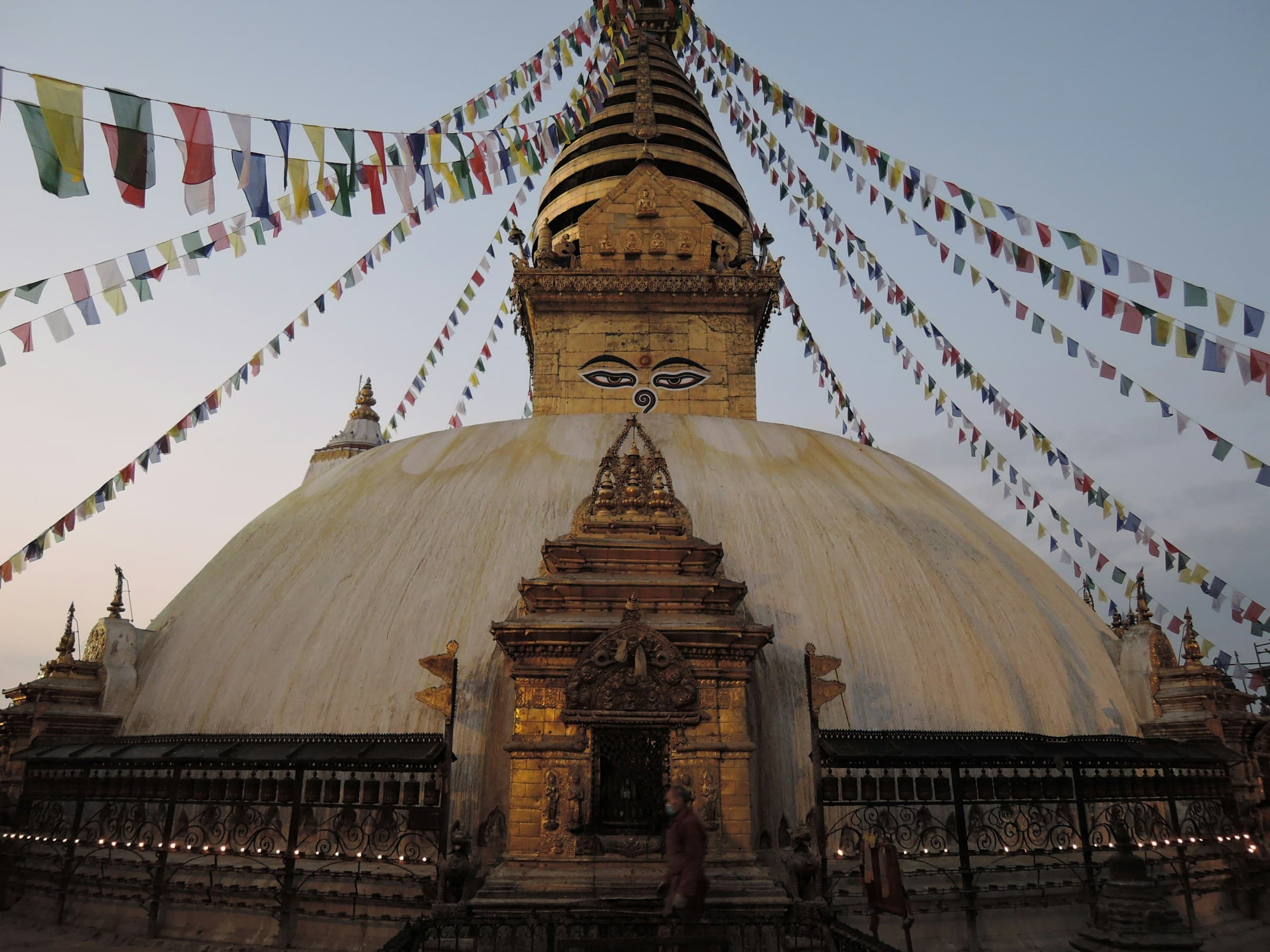 Swayambhunath Stupa at dusk, prayer flags strung from the spire