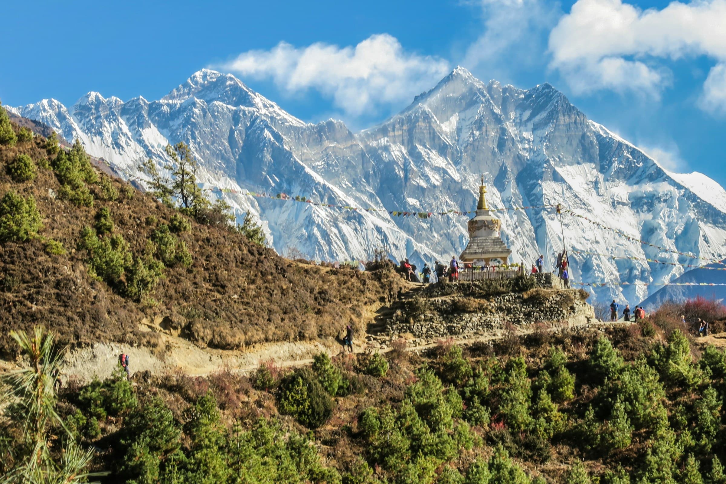 Stupa with prayer flags on the Everest trail, high Himalaya behind